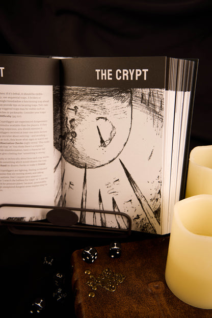 Open page spread of Best Left Buried. Title reads 'The Crypt' with a black and white illustration, next to a candle on a dark surface.
