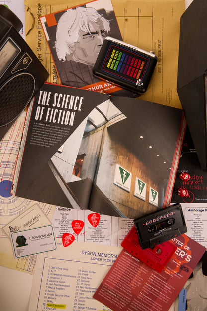 Double page spread of "The Science of Fiction" from Afterburn surrounded by cassettes and other various items